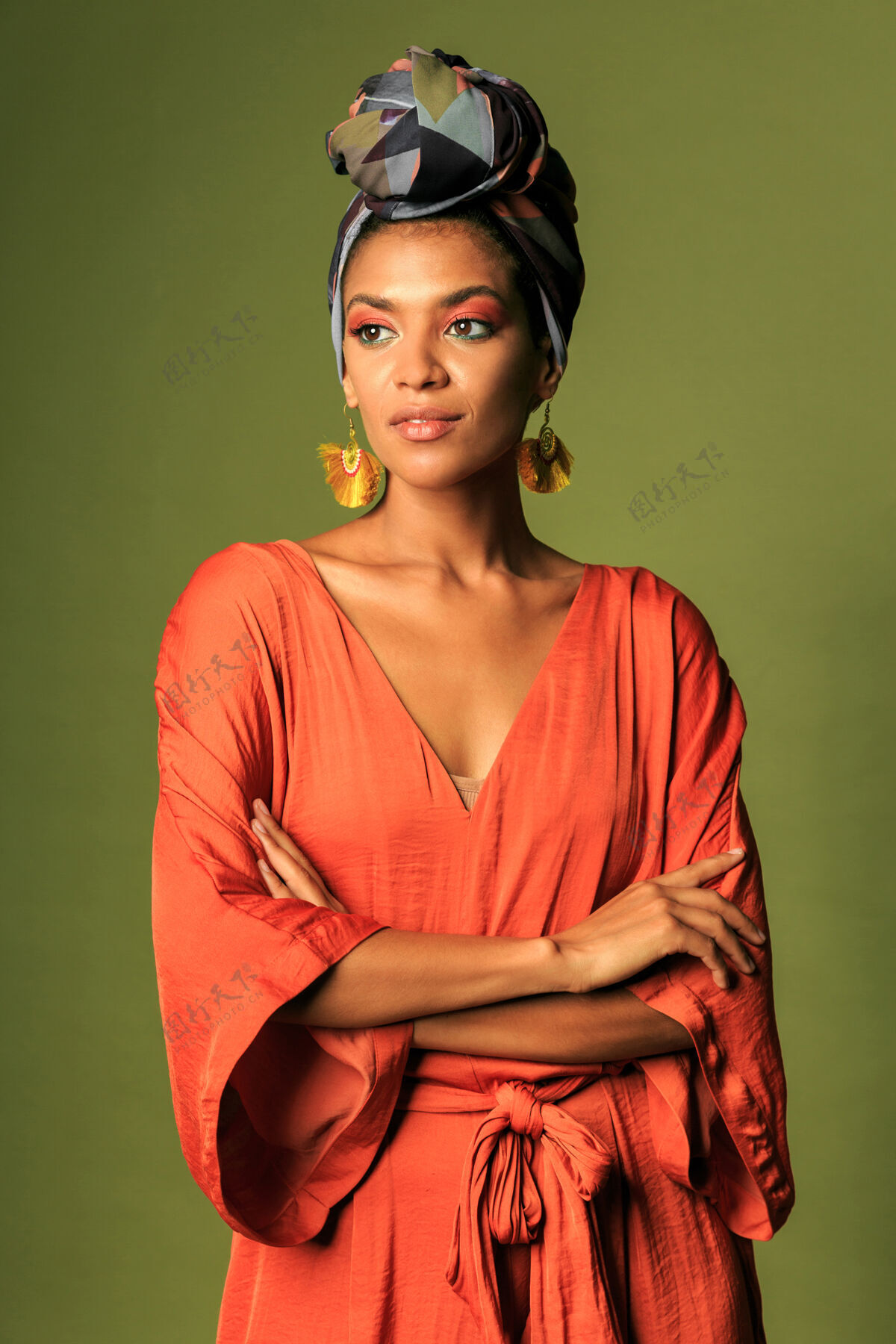 脸年轻的女人穿着橙色的裙子 戴着头巾和民族首饰配饰完美姿势