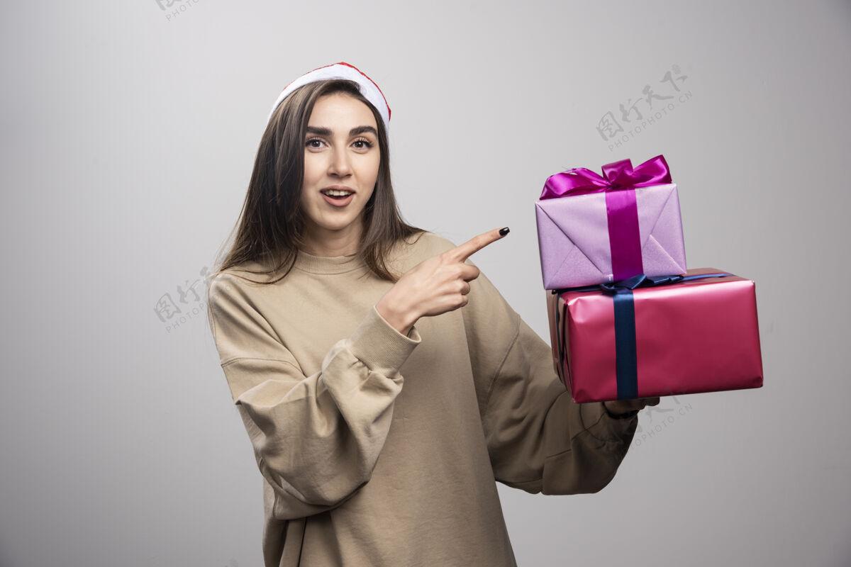 表情年轻女子指着两盒圣诞礼物漂亮年轻兴奋
