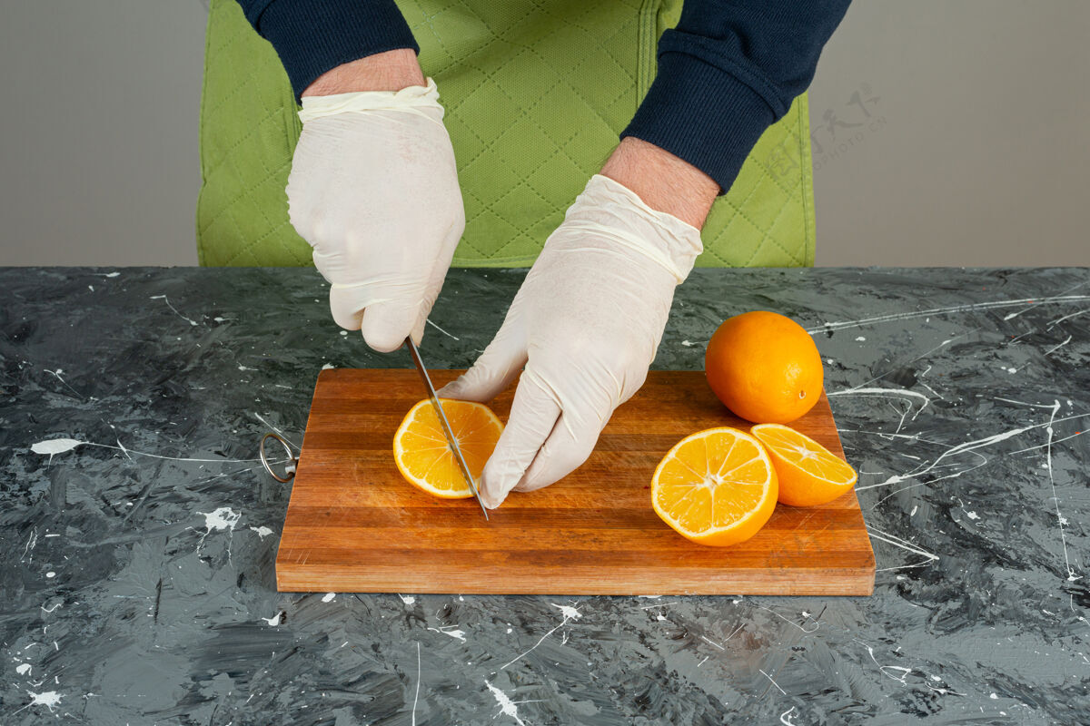 各种男性手戴手套在大理石桌上切橘子汁围裙烹饪男人