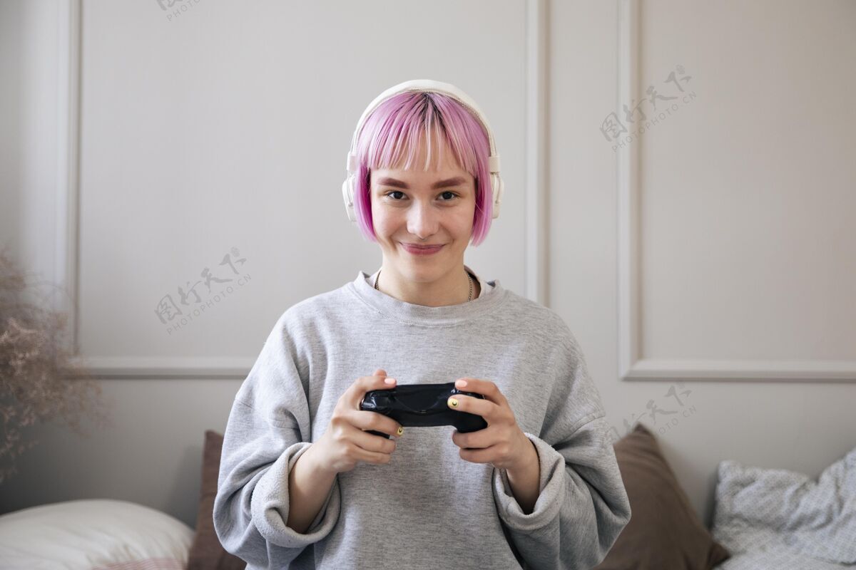 娱乐粉红色头发的年轻女子在玩电子游戏视频游戏游戏技术