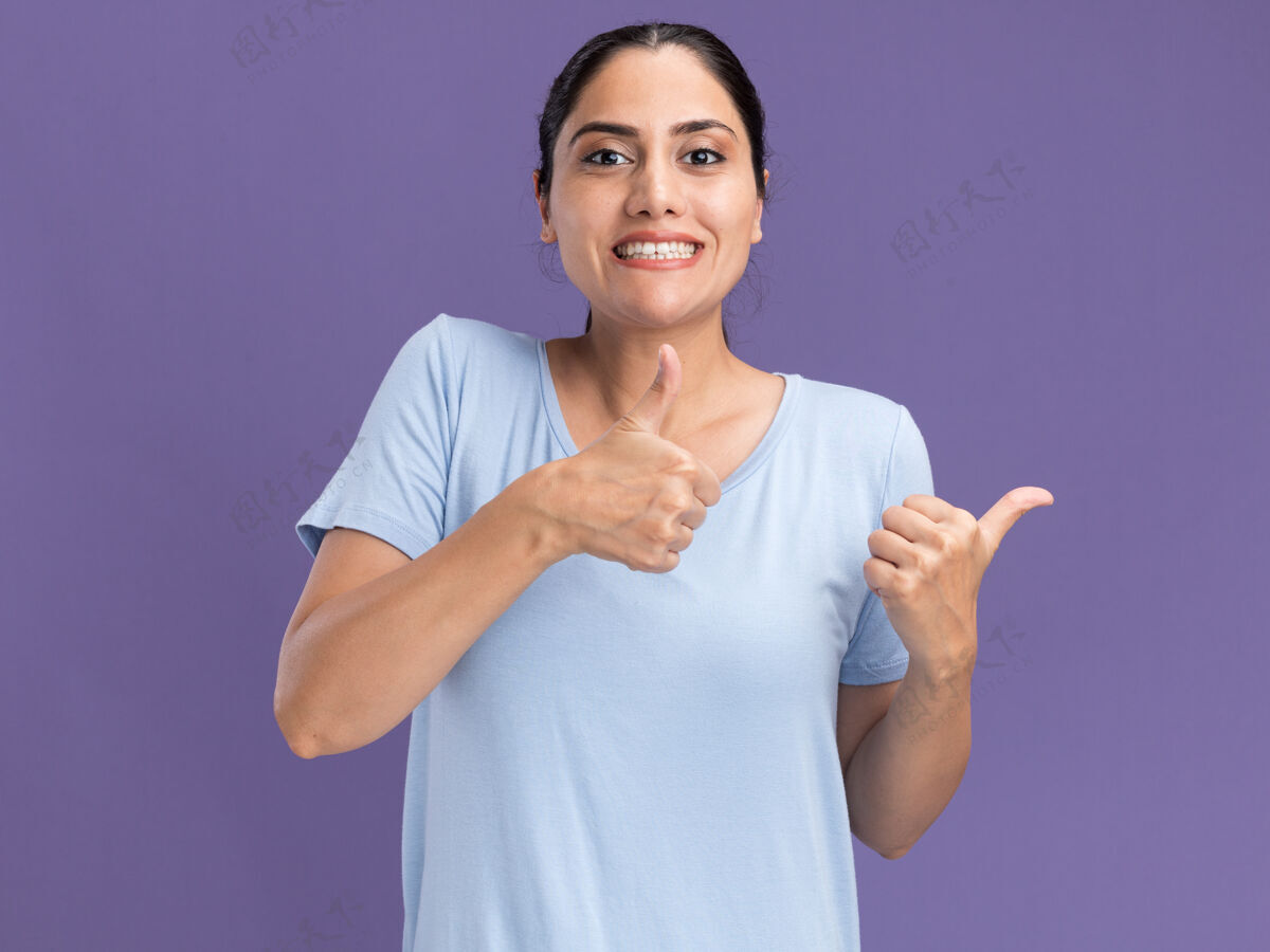 两个微笑的年轻黑发白人女孩竖起大拇指 两只手放在紫色上微笑棕色手