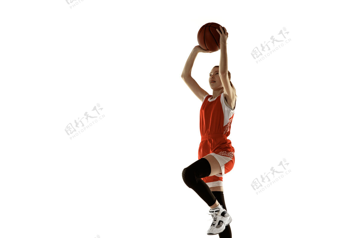 持球年轻的白人女子篮球运动员在行动 在白色背景上孤立的跳跃运动红发运动女孩运动的概念 运动 活力和动态 健康的生活方式训练运动员运动强壮