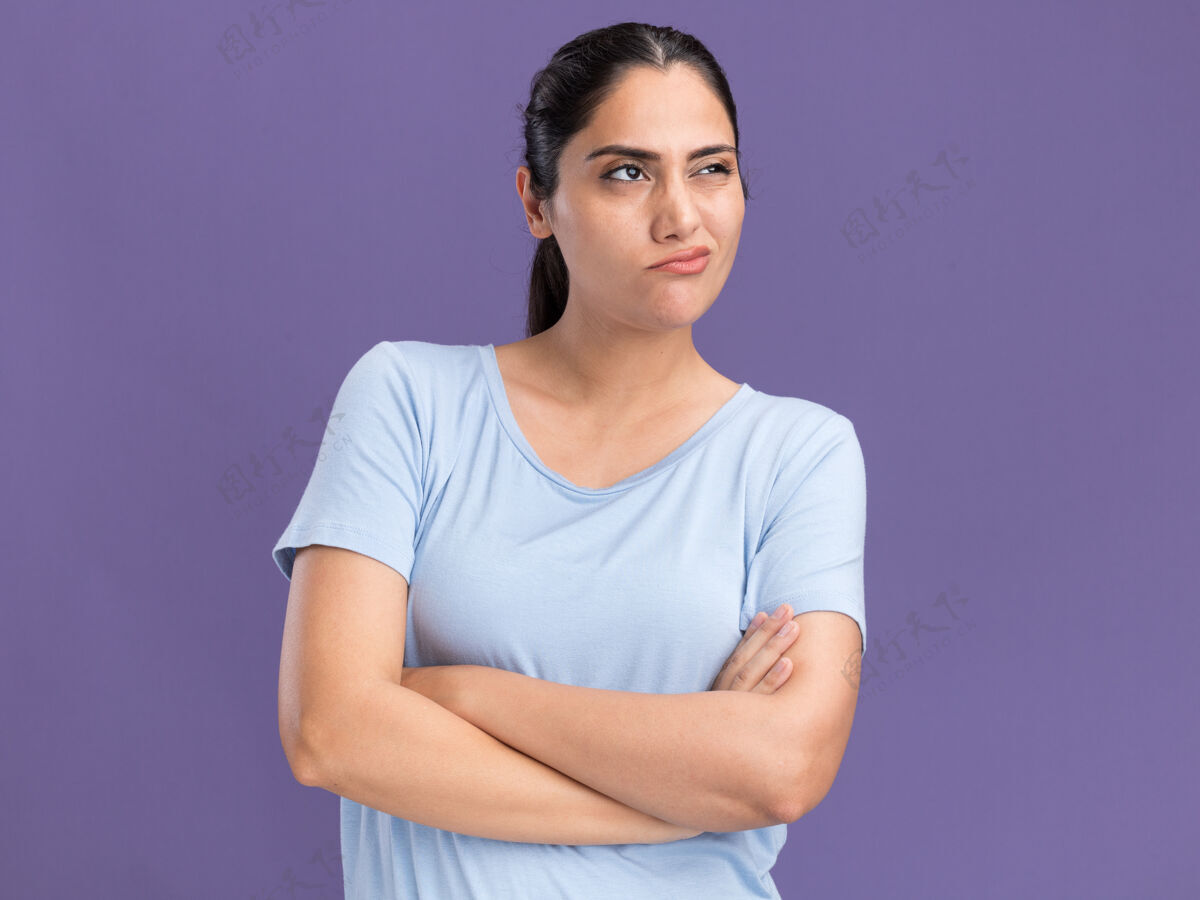 侧线自信的年轻黑发白人女孩交叉双臂站在一边看着紫色手臂紫色站立