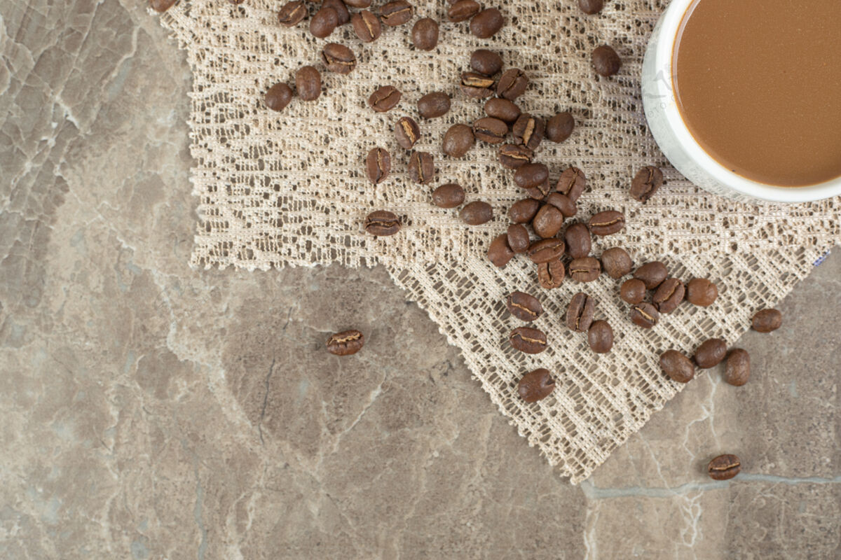 咖啡咖啡杯和咖啡豆在大理石表面与粗麻布杯子咖啡因餐
