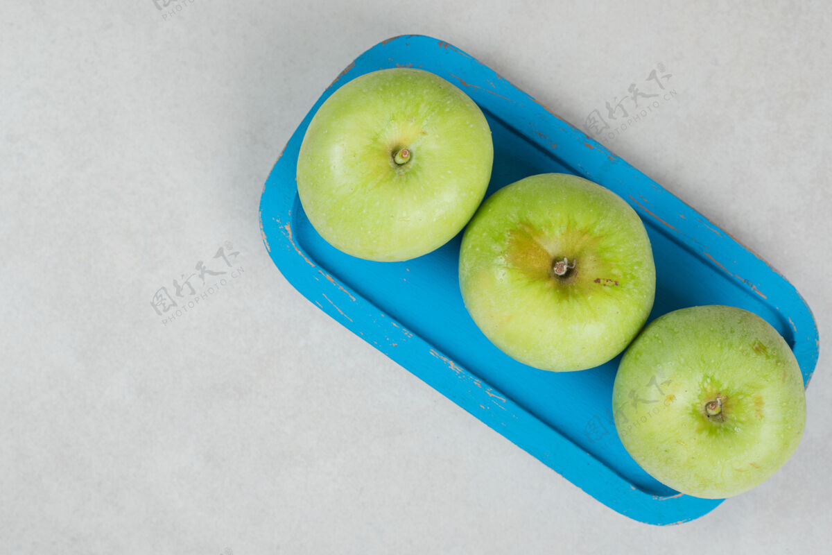 一餐青苹果放在蓝盘子里熟的有机营养