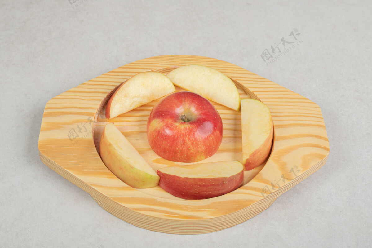切片把一整片红苹果放在木盘上配料一餐生的