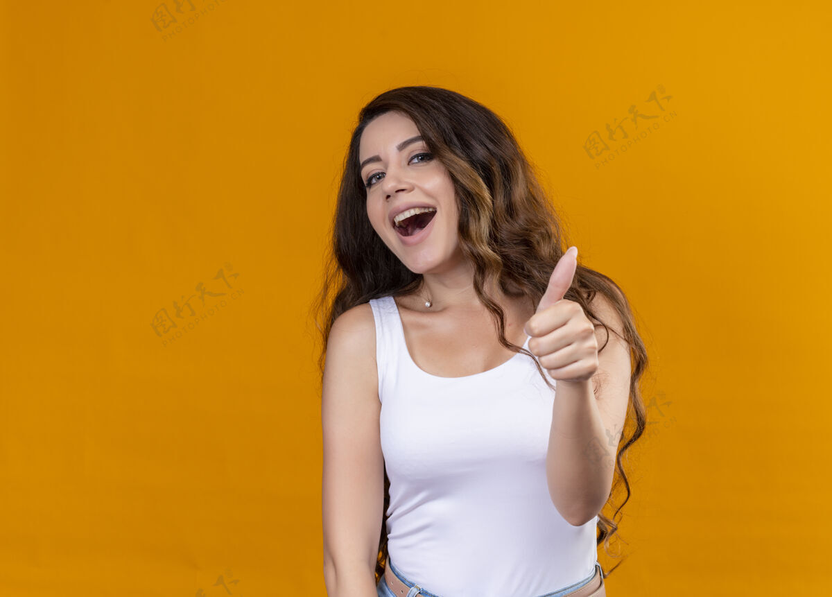 拇指快乐的年轻漂亮的女孩在孤立的橙色空间上竖起大拇指与复制空间年轻美丽女孩