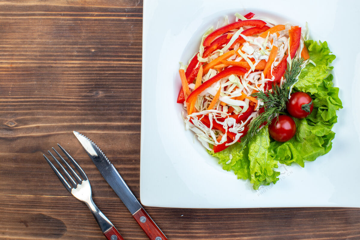 食物顶视图蔬菜沙拉与绿色沙拉和卷心菜在棕色表面盘内晚餐风景盘子