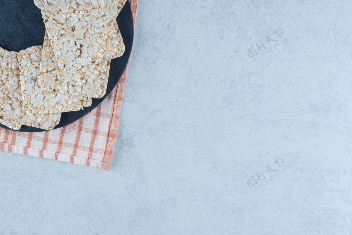 面粉酥脆的减肥食品放在大理石塔的砧板上米饭饼干毛巾