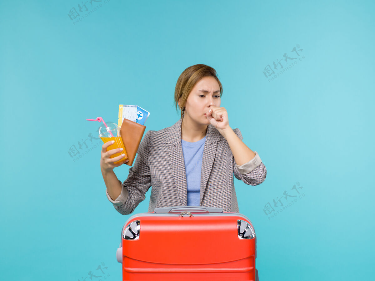 肖像前景度假中的女性手持新鲜饮料和机票咳嗽蓝色背景海上旅行度假旅行女人票咳嗽