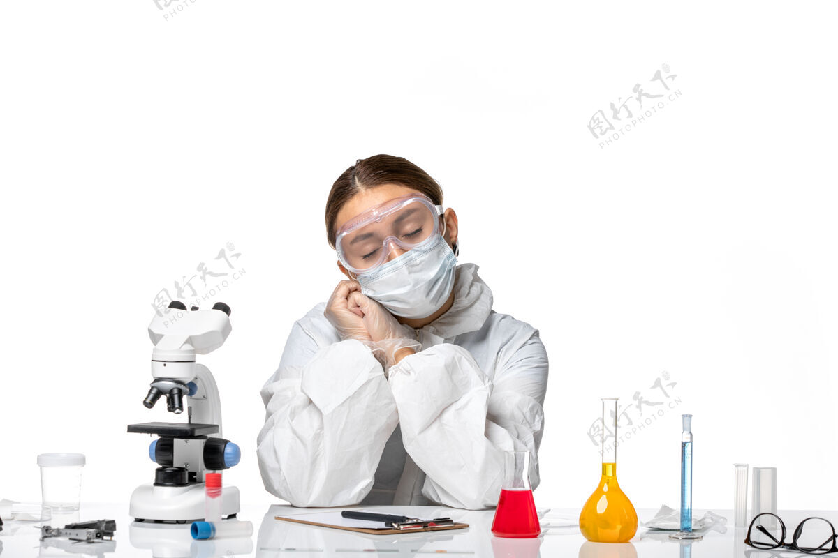 面罩正面图女医生穿着防护服 戴着口罩 坐在浅白的背景上 用解决方案对病毒药物进行治疗 预防健康大流行医生坐姿成人
