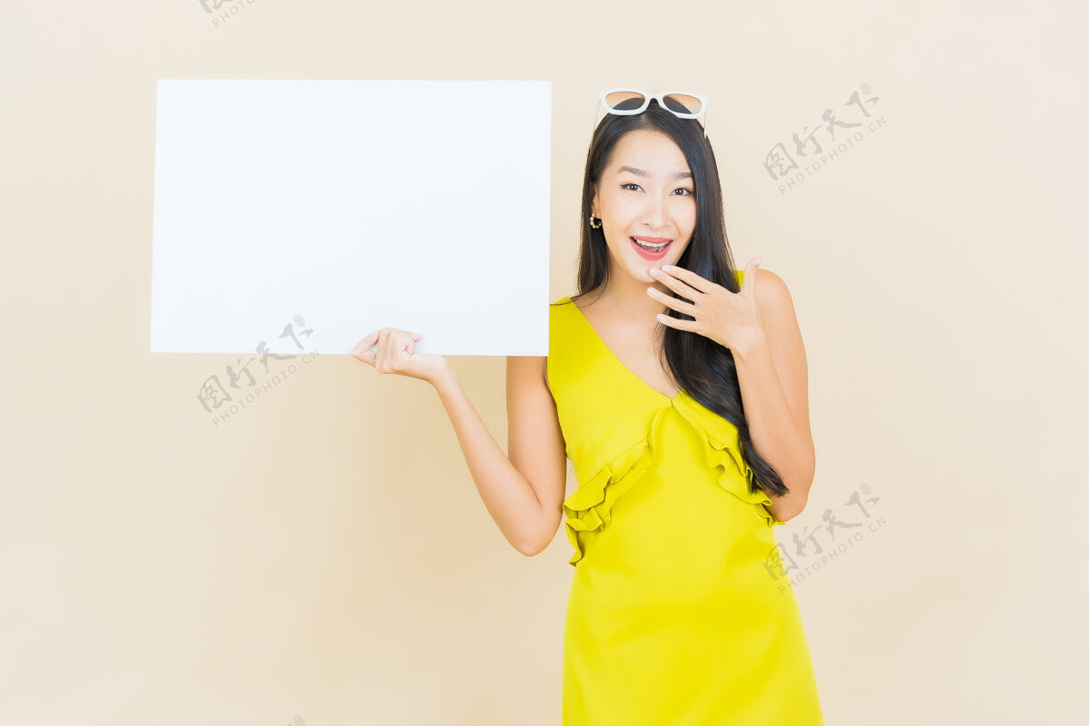 微笑一幅美丽的亚洲年轻女子微笑的画像 黄色的墙上挂着白色的白板中国人空白脸