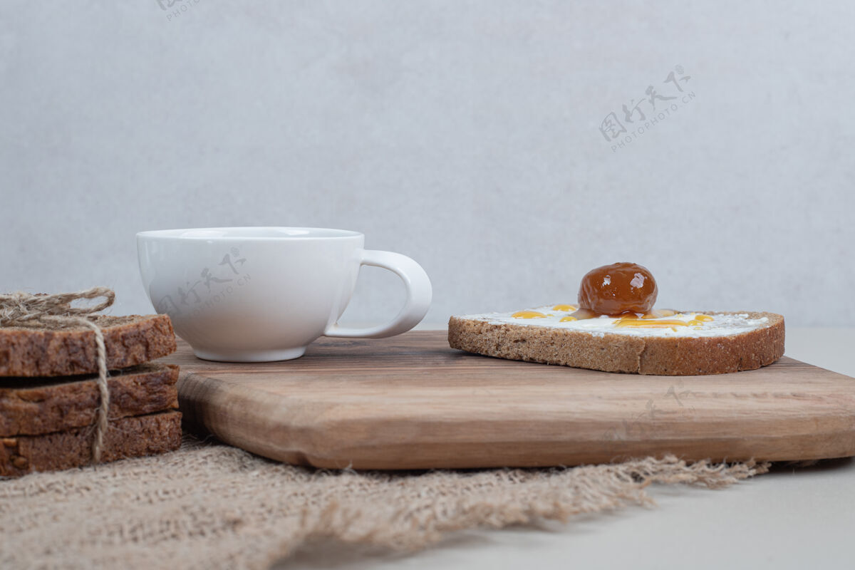 食物麻布上放着烤面包和茶的木制砧板好吃木板面包