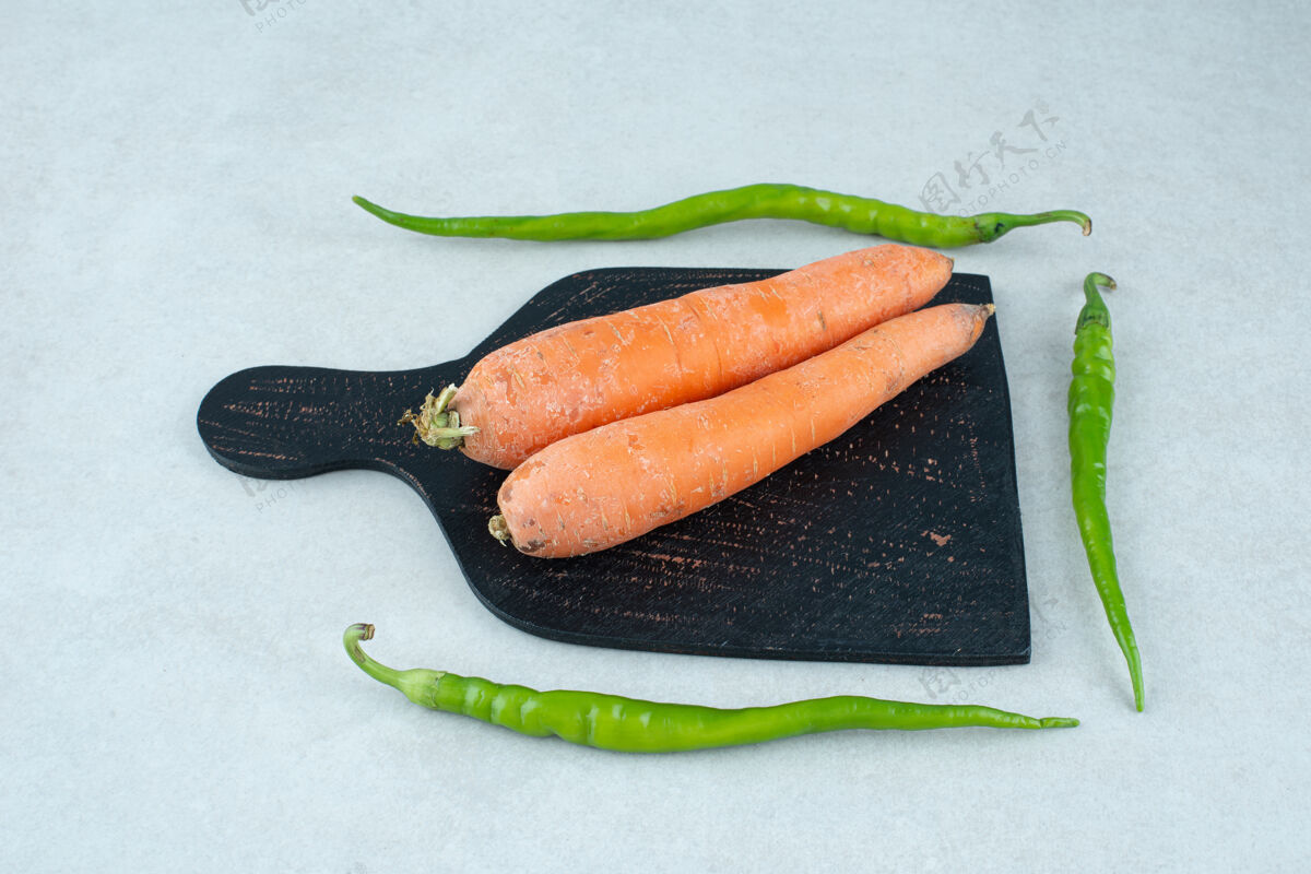 蔬菜成熟的胡萝卜和胡椒放在深色的木板上胡椒胡萝卜成熟