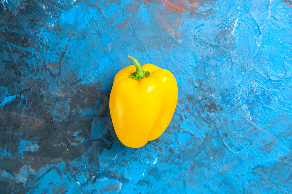 有机蓝色表面上黄色甜椒的顶视图番茄沙拉健康