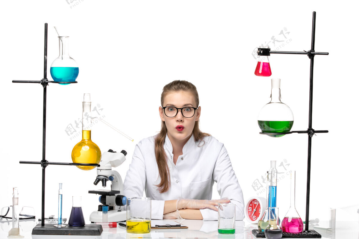女化学家前视图身着医疗服的女化学家在桌子前拿着白色背景上的溶液大流行化学冠状病毒成人桌子观点