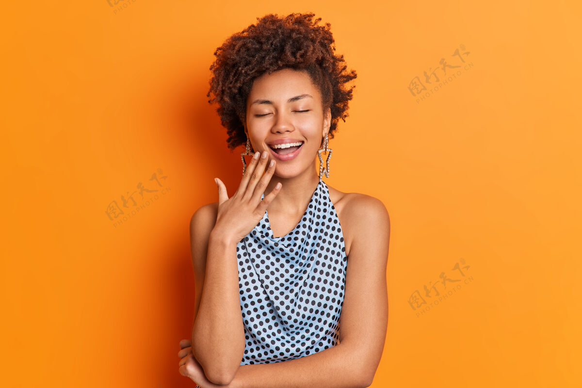人积极无忧无虑的非洲裔美国妇女笑得开心闭上眼睛积极请橙色