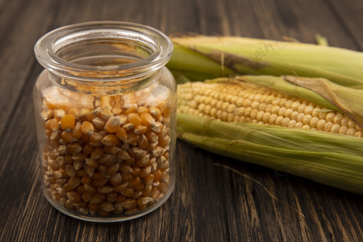 玻璃顶视图有机和新鲜玉米与头发玉米粒上的玻璃罐在一个木制的桌子上新鲜玉米美味