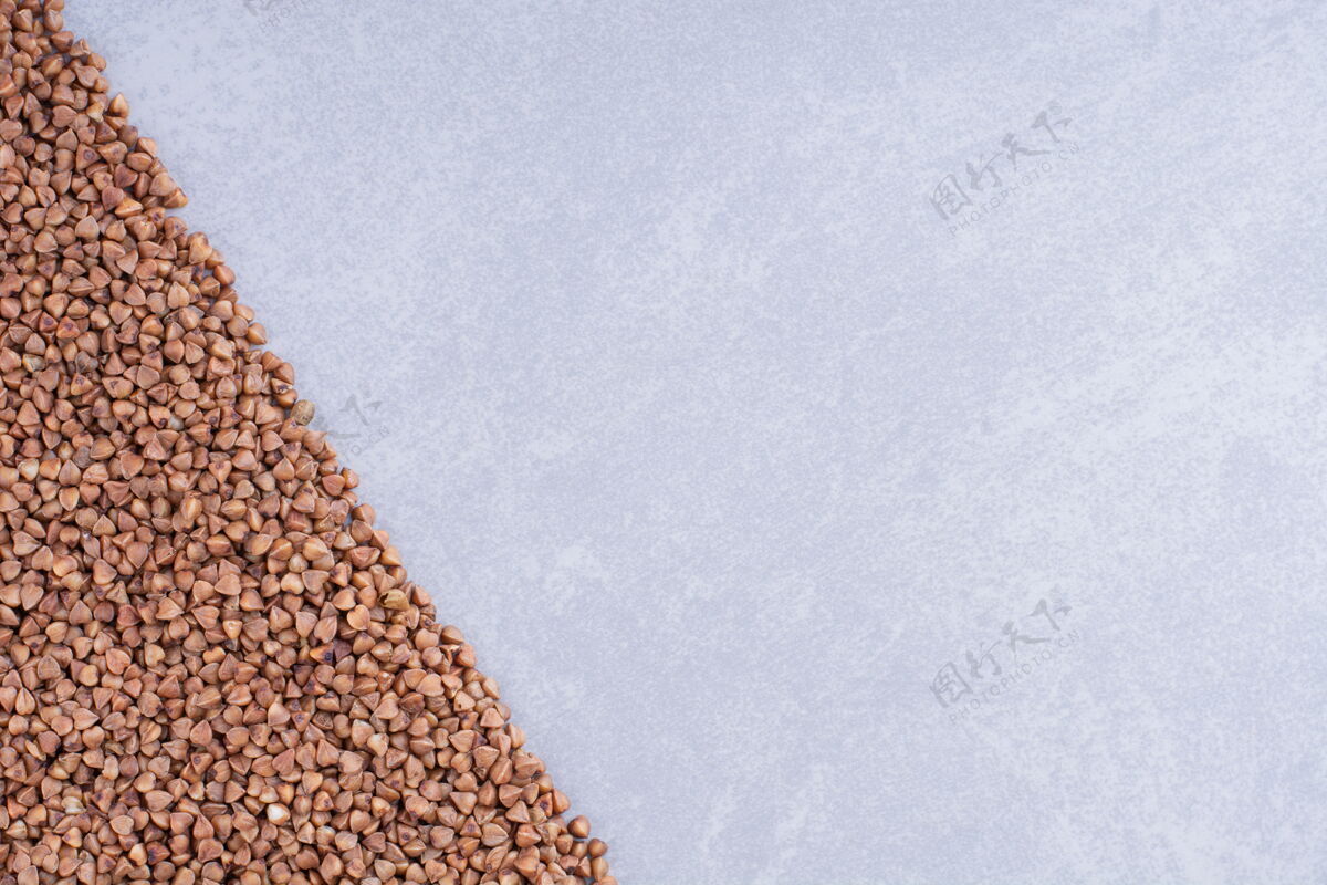 荞麦一堆荞麦摆成三角形放在大理石表面谷物饮食配料
