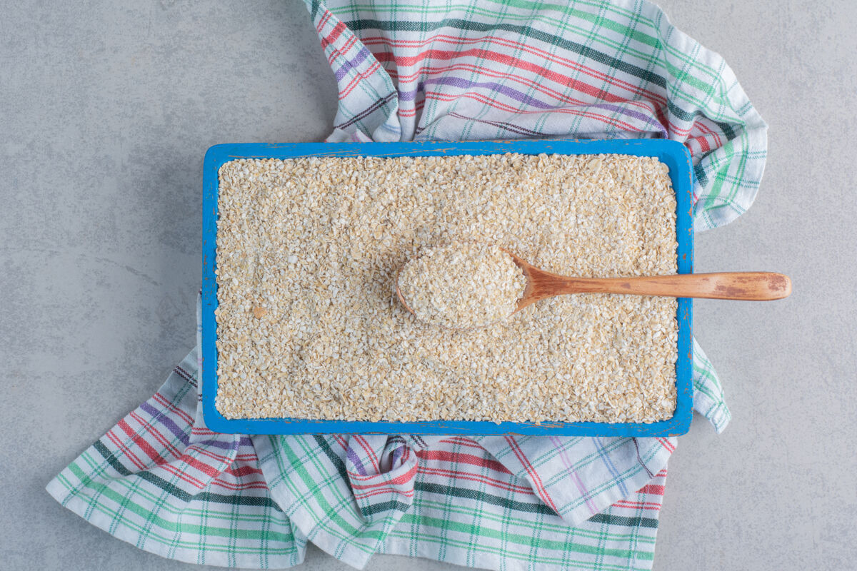 勺子在大理石表面的毛巾上放满了米饭的盘子配料毛巾谷物