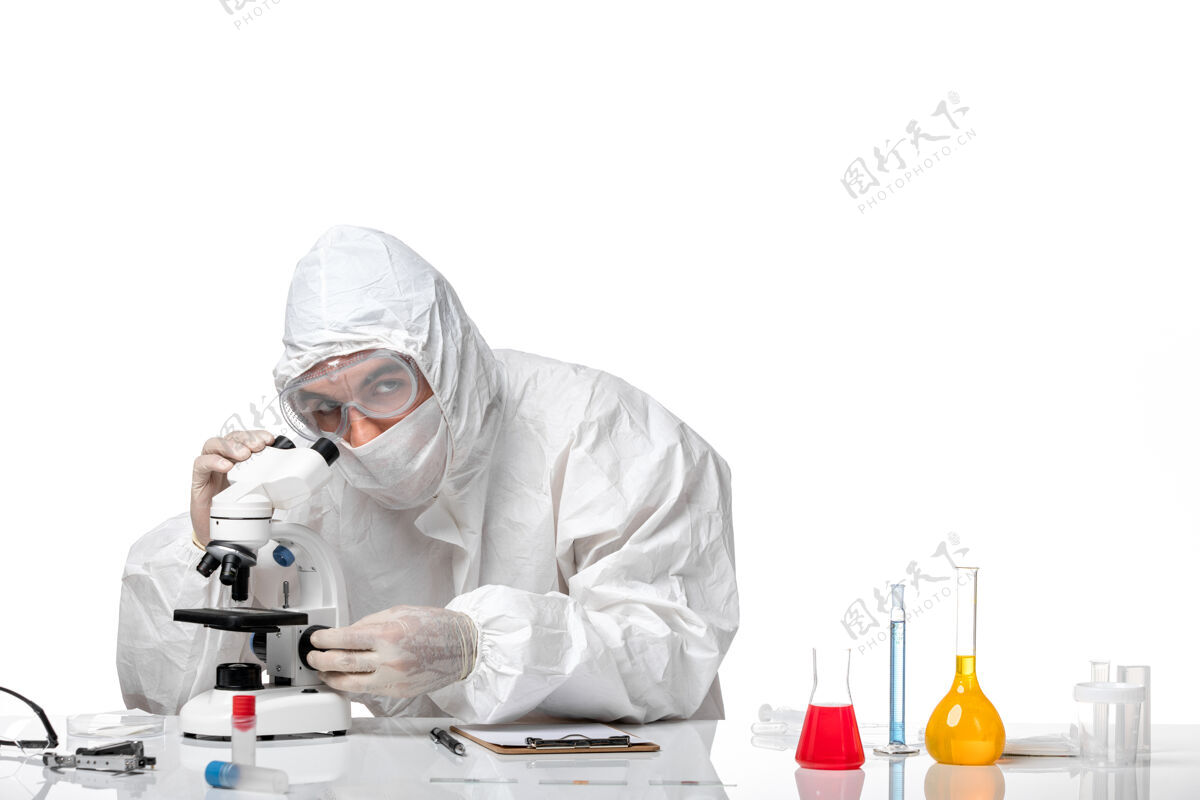 男医生正面图：男医生穿着防护服 戴着面罩 在空白处使用显微镜实验室外套套装防护