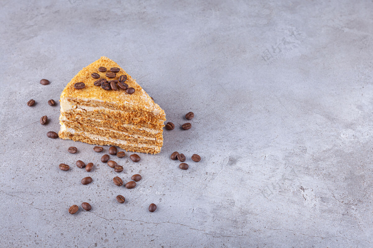 糖把一片分层的蜂蜜蛋糕和咖啡豆放在石头背景上面包房蜂蜜奶油