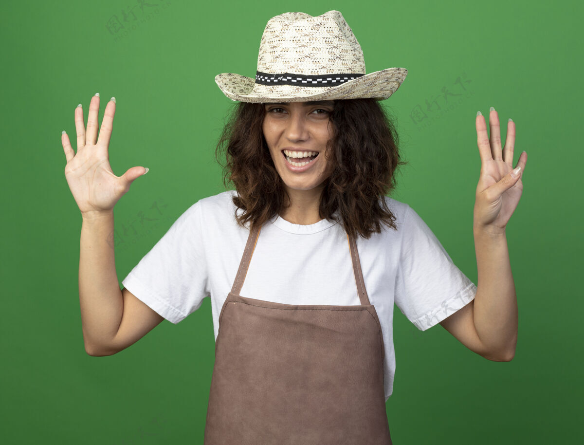 不同微笑的年轻女园丁 穿着制服 戴着园艺帽 在绿色上显示不同的数字花园绿色年轻