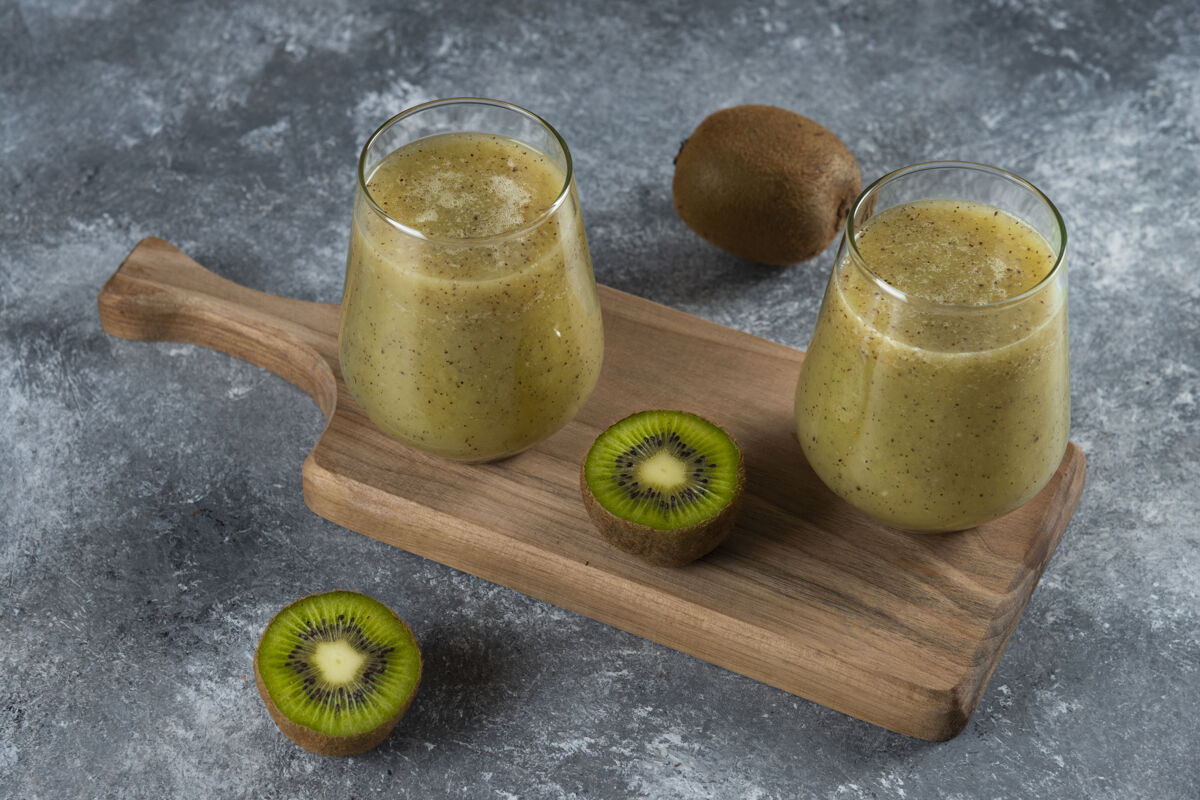 美味两杯美味的猕猴桃汁放在木板上水果自然美味