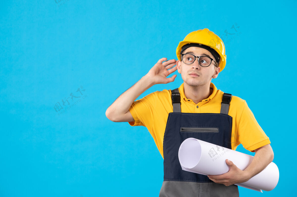 建筑正面图：身穿黄色制服的男性建筑工人 蓝色平面图制服人承包商