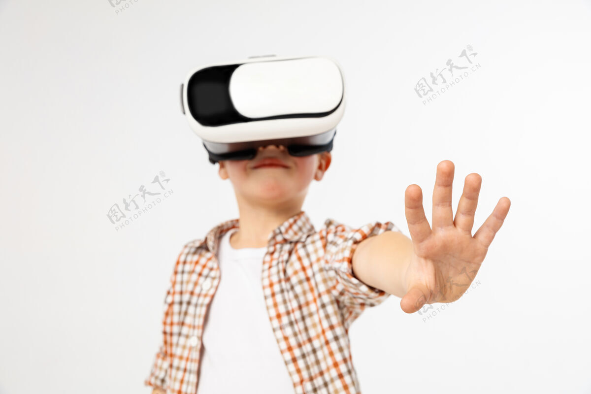 游戏触摸奇迹穿着牛仔裤和衬衫 戴着虚拟现实耳机眼镜的小男孩或小孩 在白色工作室背景上隔离开来尖端技术的概念 视频游戏 创新视频科技儿童