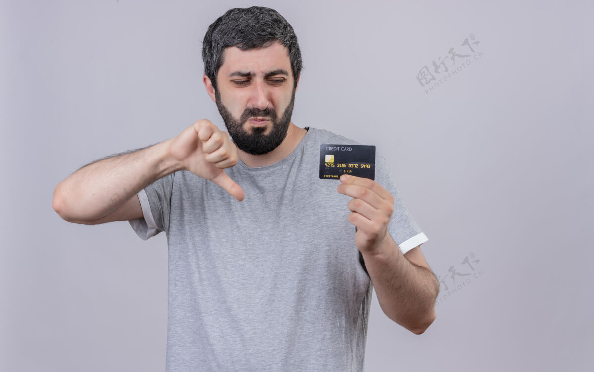英俊一个年轻英俊的白种人 正在看信用卡 在白色的背景上孤立地竖起大拇指 留着复印空间信贷不愉快显示