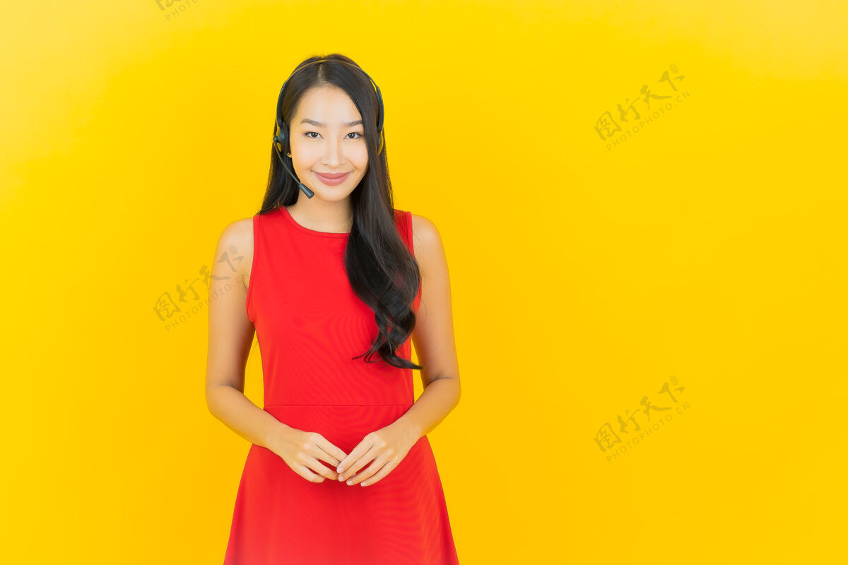 办公室肖像美丽的亚洲年轻女子与耳机沟通和支持呼叫中心服务黄墙耳机商务女性商务