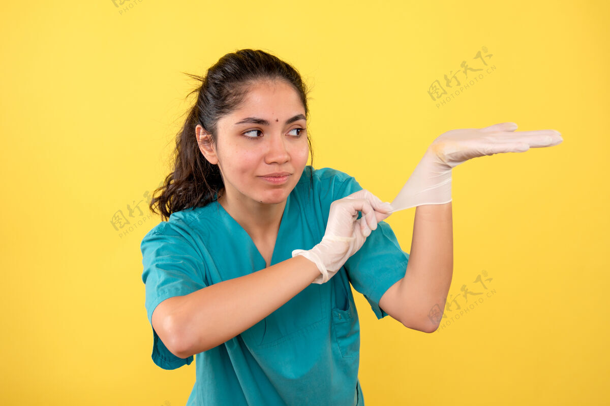 女医生正面图：戴着乳胶手套的女医生站着人欢呼年轻