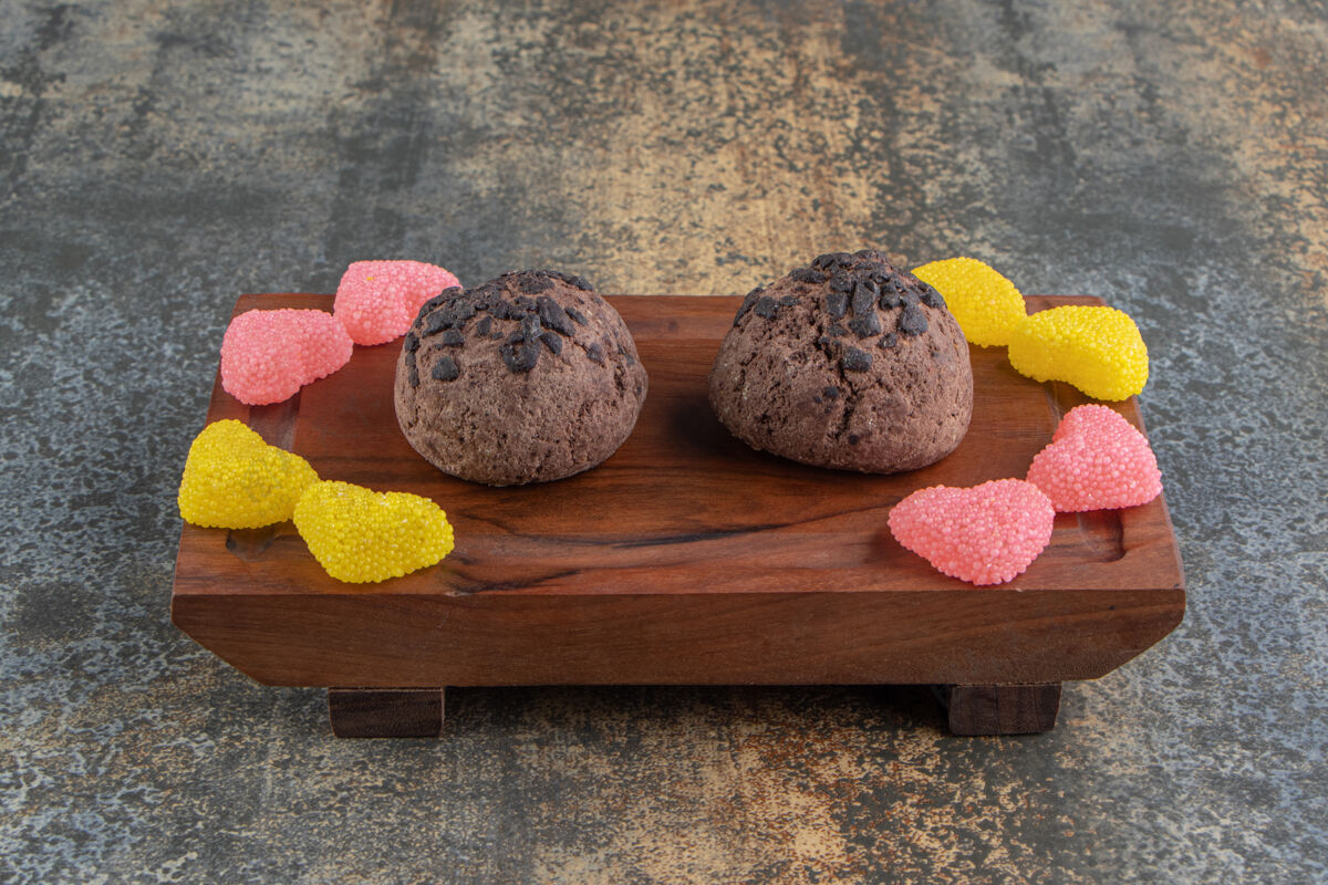 正餐两块巧克力饼干和果酱糖放在木盘上饼干美味可口
