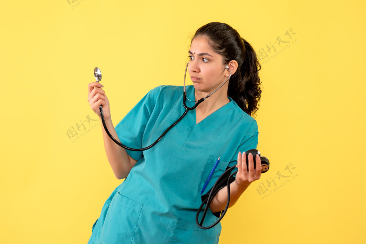 女医生前视图穿着制服拿着血压计的女医生人黄色成人