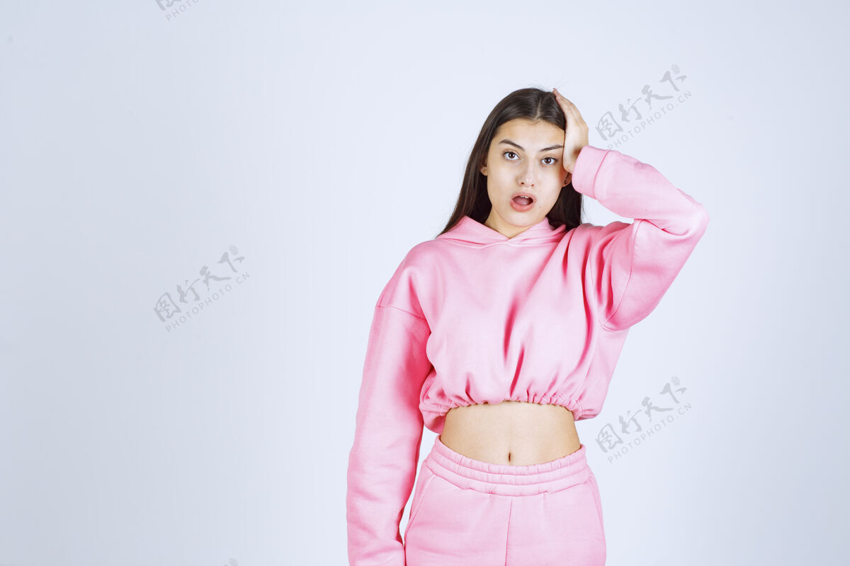 女人穿粉红色睡衣的女孩看起来既震惊又害怕女性姿势惊喜