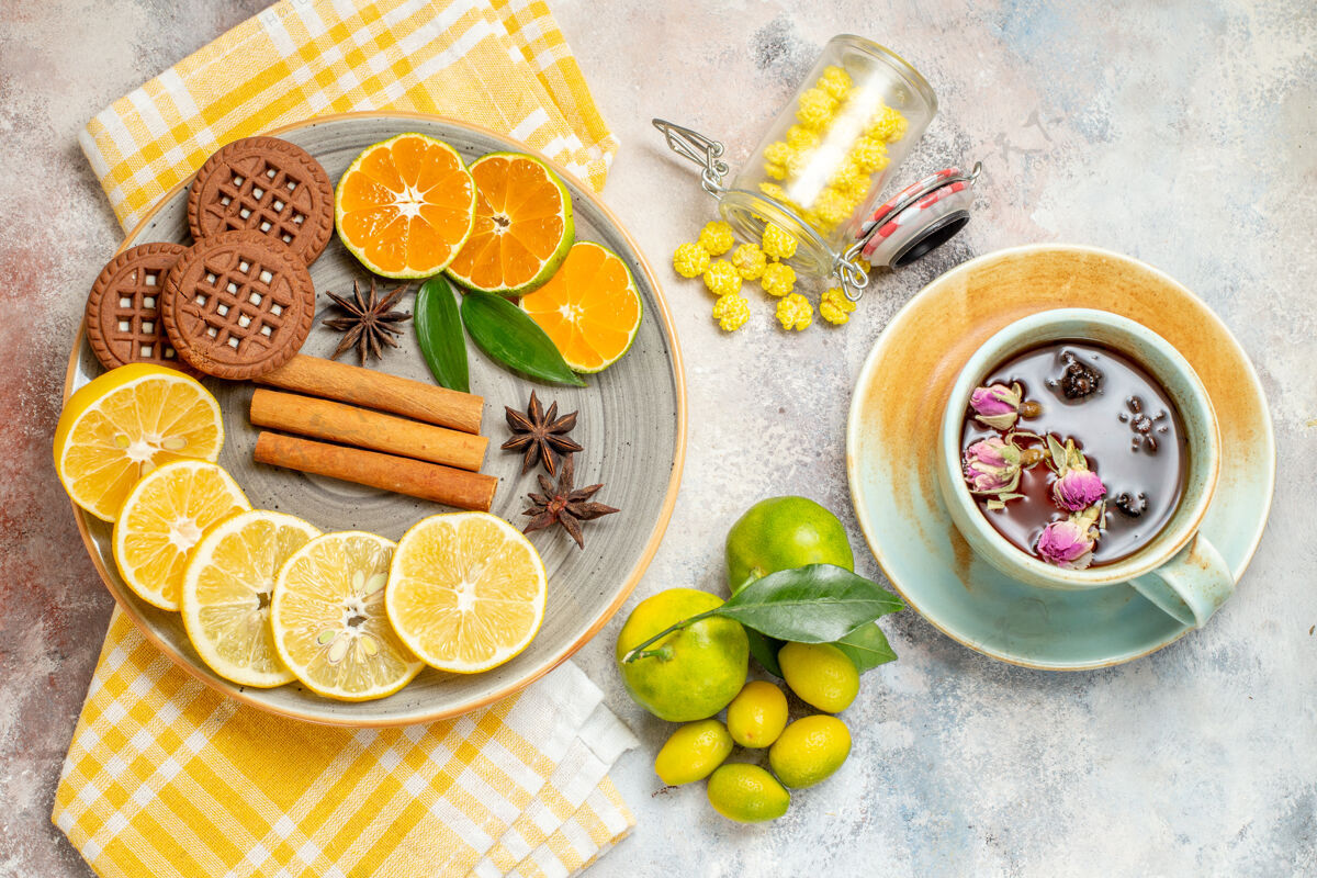 柑橘木制砧板上柠檬片 肉桂 酸橙和白桌子上饼干的俯视图营养开销食品
