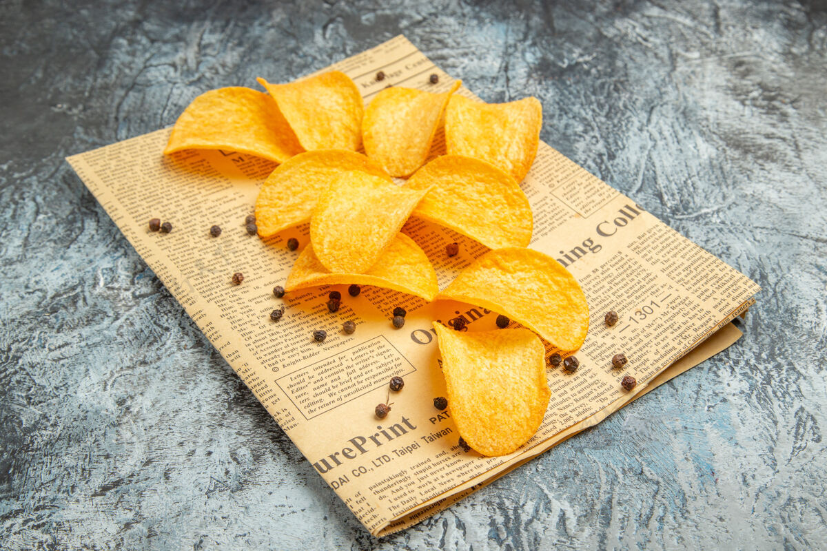 新鲜美味的自制薯片在报纸上的灰色桌股票图片甜点自制薯条烘焙
