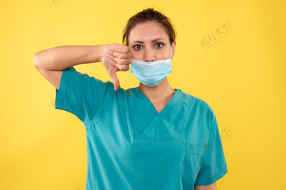 健康黄色背景上戴着无菌口罩的女医生的前视图人女医生肖像