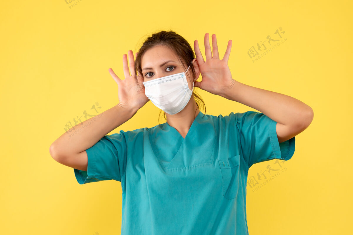 人正面图黄色背景上穿着无菌口罩医用衬衫的女医生肖像正面绝育