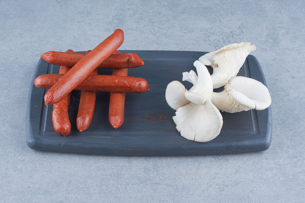 单一有机牡蛎蘑菇和香肠放在木板上美味真菌饮食