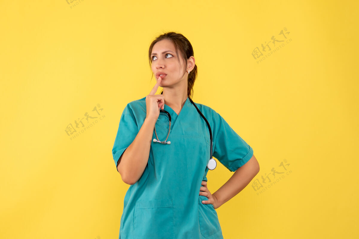 医疗正面图黄色背景上穿着医用衬衫的女医生在思考病毒女医生视图