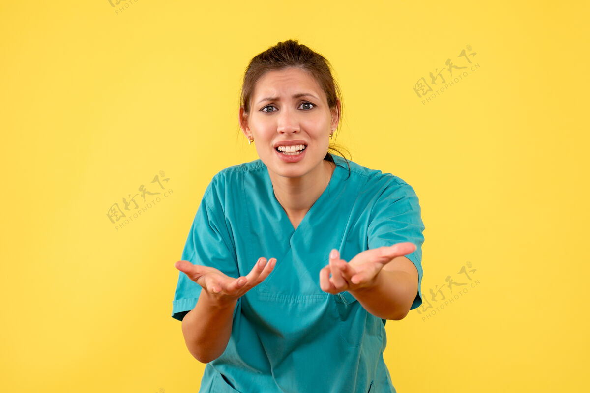 病毒前视图黄色背景上穿着医用衬衫的女医生成人女医生衬衫