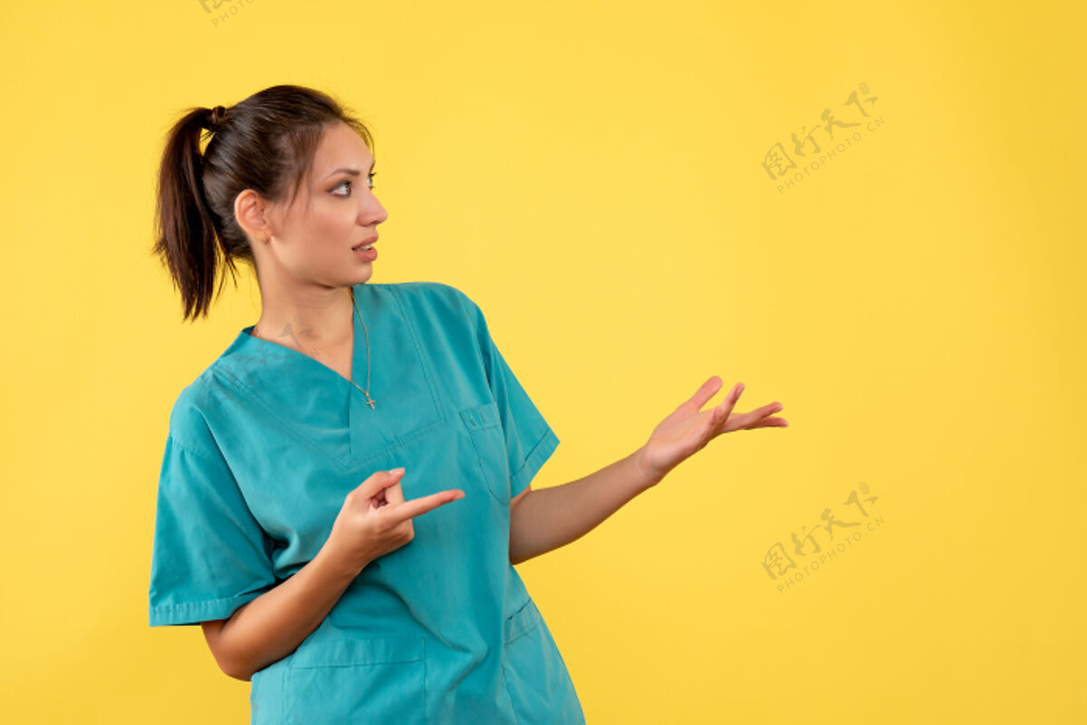 女医生前视图黄色背景上穿着医用衬衫的女医生正面黄色肖像