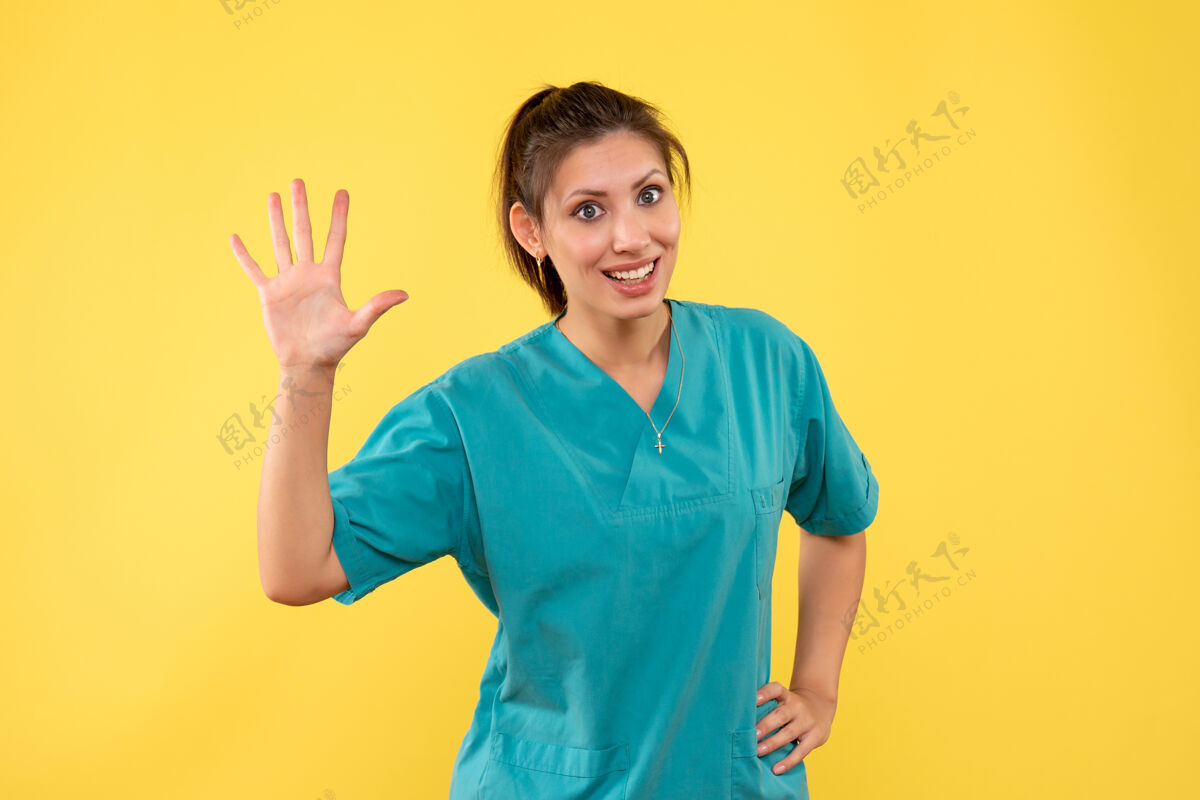 正面前视图黄色背景上穿着医用衬衫的女医生健康微笑视图