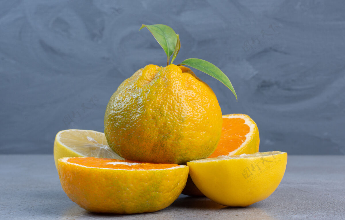 美味整个橘子放在柠檬上 橘子片放在大理石背景上新鲜天然健康