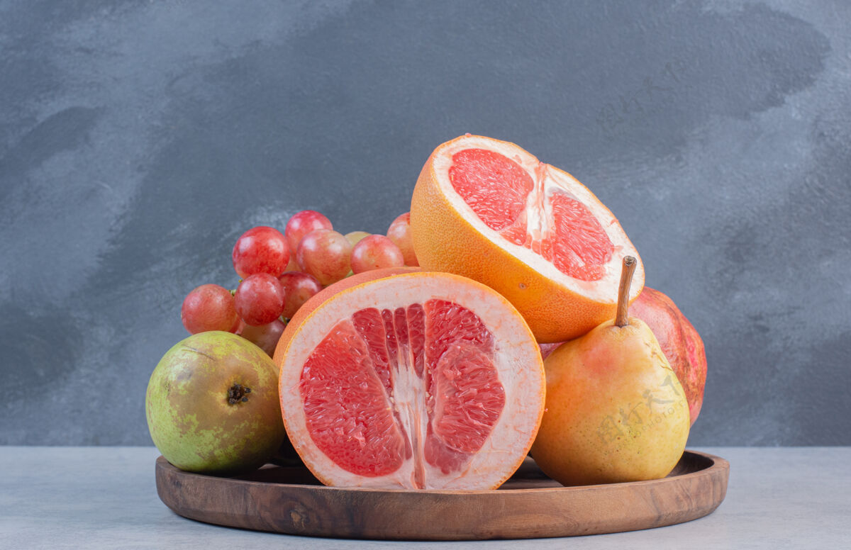 变化装满时令水果和半切柚子的木板水果碗苹果收集