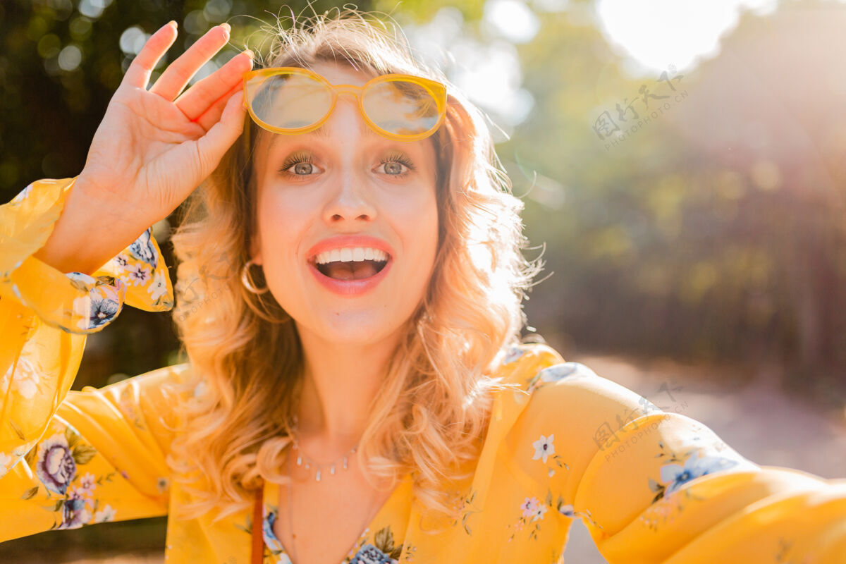 配饰美丽的金发时尚微笑的黄色女衬衫戴墨镜自拍照片的肖像黄色女孩女人