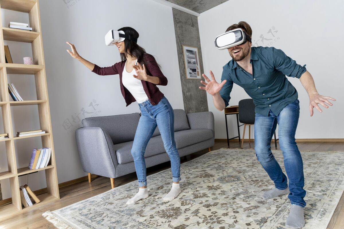 娱乐微笑的男人和女人在家里玩虚拟现实耳机的乐趣女人娱乐水平