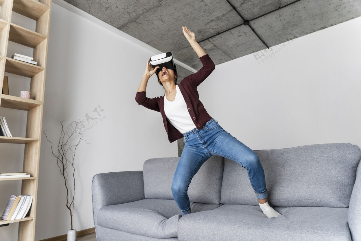 水平用虚拟现实耳机在家里玩得开心的女人房子乐趣娱乐